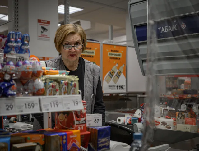 Supermarket scene with cashier and assortment of products at checkout counter. Marginaler i detaljhandeln: bruttovinst, kostnader och prissättning